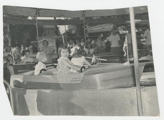 Children in a small boat, amusement attraction, Joyland Park - stamped on back of photograph MACK HUGHES PHOTOGRAPH 503 E. HIGH LEXINGTON, KY