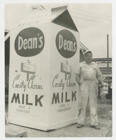 Dean's Country Charm Milk Grade A Homogen, man standing next to giant milk carton, Joyland park; advertisement
