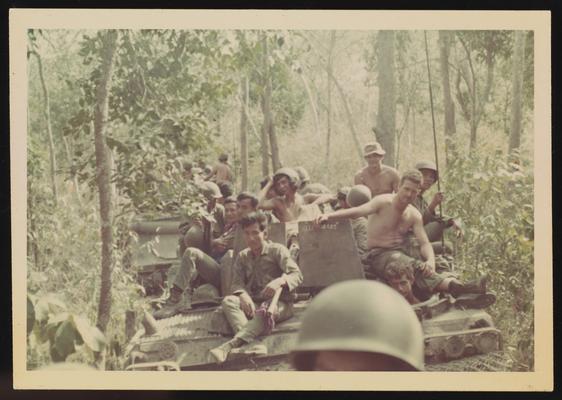 Tanks going through jungle, several members of the Army of Vietnam on top