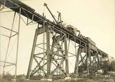 People using cranes and trains to construct High Bridge