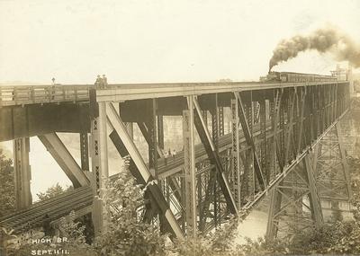 Men sitting and standing on High Bridge-train on top tracks