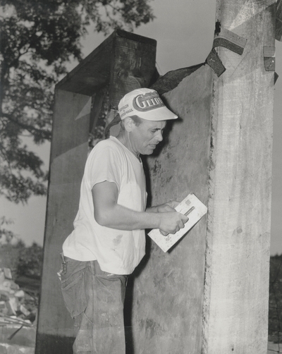 John Jacob Niles applying plaster to rammed-earth walls; Boot Hill Farm