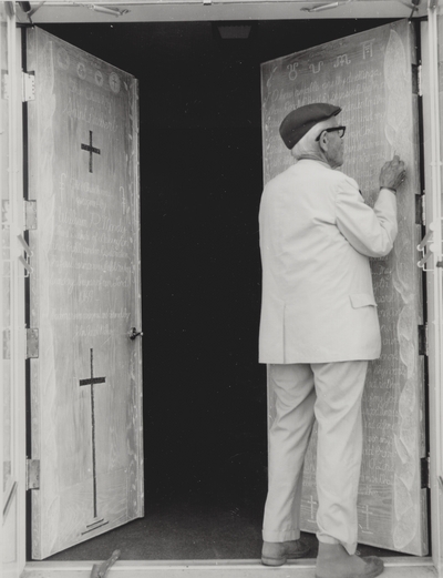 John Jacob Niles puts the finishing touches on carving of doors for St. Hubert's Church