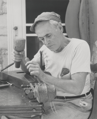 John Jacob Niles outdoors working on dulcimers at Boot Hill Farm; Louisville Courier-Journal
