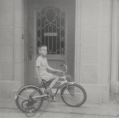 John Ed Niles on bicycle in front of Lipetz home; Albany, New York