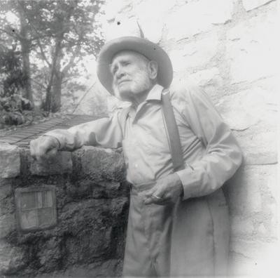 John Jacob Niles leaning against a wall