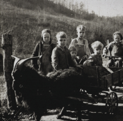 Mountain children with goat on dirt road