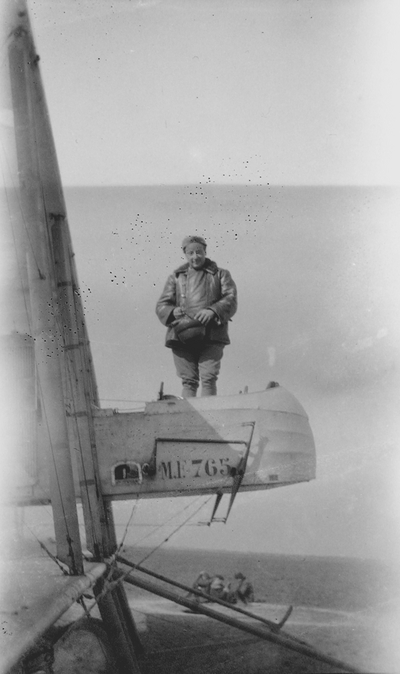 Pilot standing on wing of plane