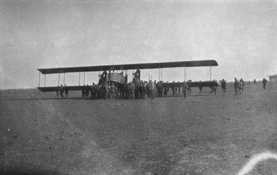 Men around biplane in field