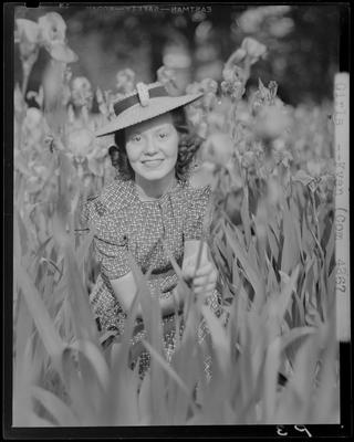 Sara Biggs squatting in a field of flowers; (1940 Kentuckian)                             (University of Kentucky)
