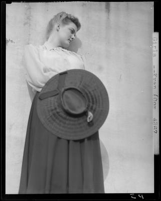 Mattigene Pallmore holding a large hat in front of her; (1940                             Kentuckian) (University of Kentucky)