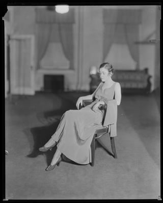 Young woman in evening gown, seated in chair
