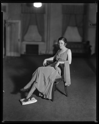 Young woman in evening gown, seated in chair