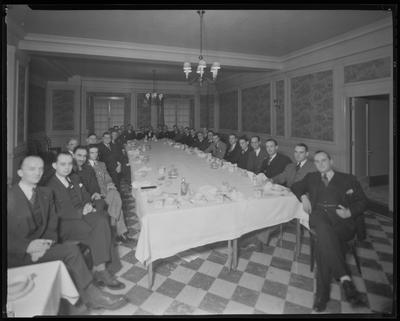 Young men seated around a table