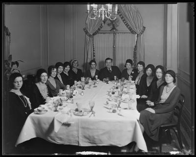 12 young women, seated at a dining table