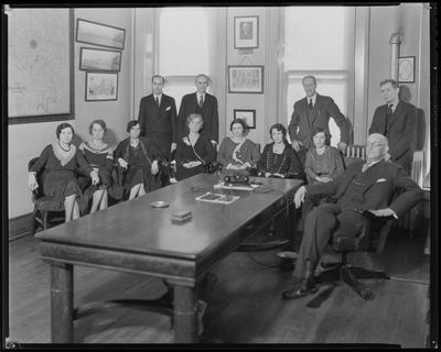 Women sitting at table, men standing