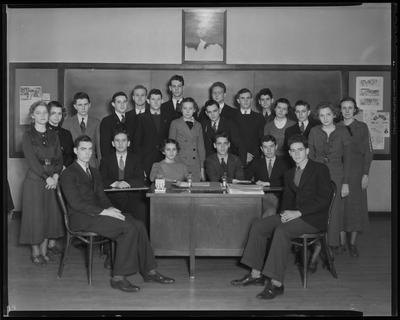 Students standing behind a desk
