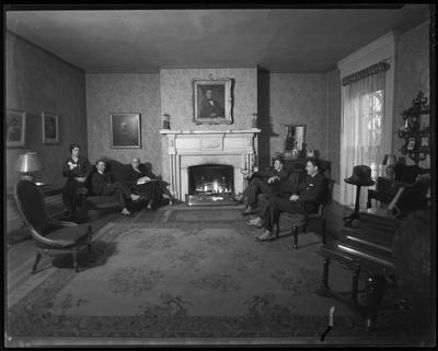 4 men and a woman in a sitting room