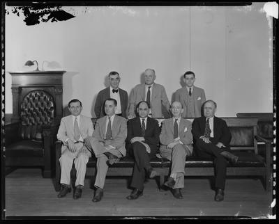 7 men sitting near lectern (DAMAGED)