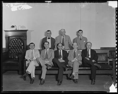 7 men sitting near lectern (DAMAGED)