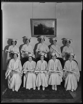 Young women in robes, holding diplomas