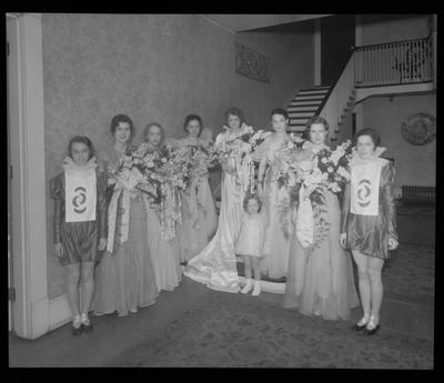 8 young women, child in costumes (beauty pageant?)