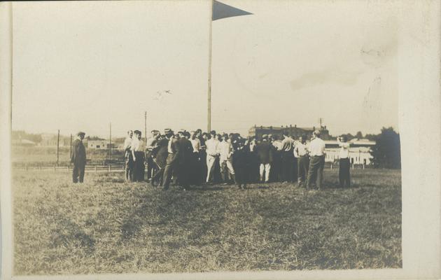 1910 Freshman-Sophomore flag rush, flag with a group of people gathered around the pole circa 1910
