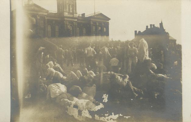 people wrestling on ground, people watching and standing around circa 1910