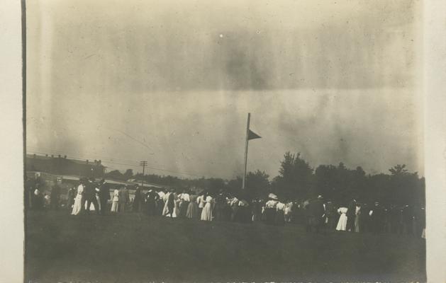 flag with people all around the lawn circa 1910