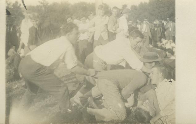 a group of men wrestling on ground circa 1910