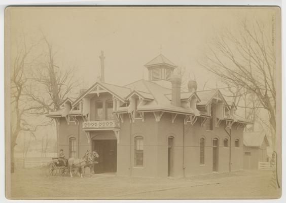 Unidentified man in a horse carriage in front of the carriage house at Bell Place