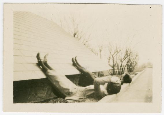 Two women lying on their backs with their legs up on a roof