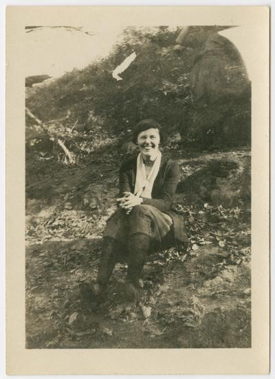 Margaret Horsefield from North Carolina, French teacher, 1919-1923, sitting on the ground with a bank in the background