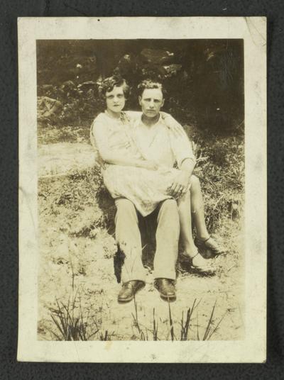 Unidentified white couple sitting in a yard or garden