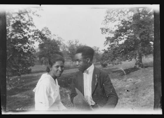 Negative of unidentified man and woman in field