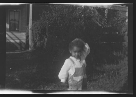 Negative of unidentified child in a yard