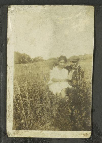 Page 1 [L]: Unidentified black man and woman sitting in a field