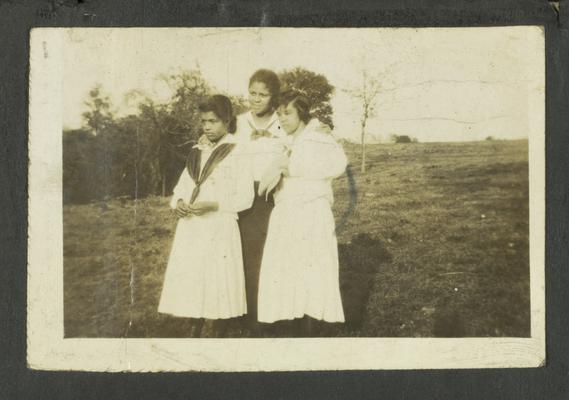 Page 2 [R]: Three unidentified young black girls standing in a field