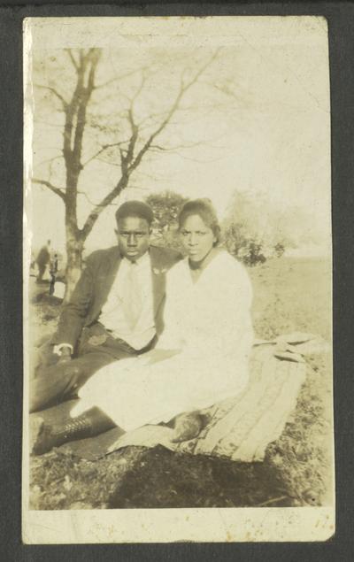 Page 3 [L]: Unidentified black man and woman sitting on a blanket in a field