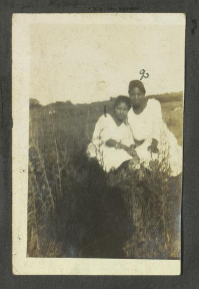 Page 5 [L]: Two unidentified black women sitting in a field