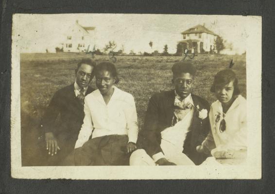 Page 6 [L]: Two unidentified black men and women sitting in a field