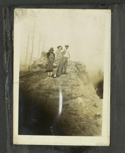 Page 7 [L]: Unidentified black man and two women standing on a rocky hill