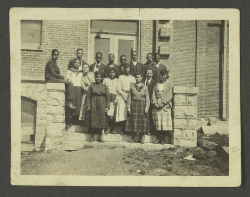 Page 11: Group photo of unidentified black men and women on steps of building