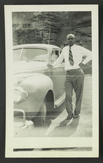 F.A. Wilson on top of Norris dam, posing with car
