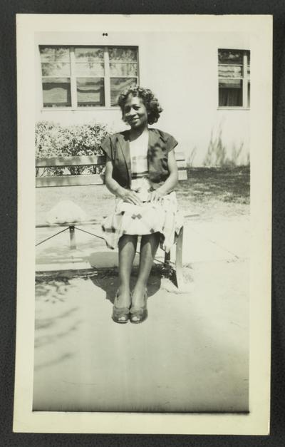 Unidentified black woman sitting on bench