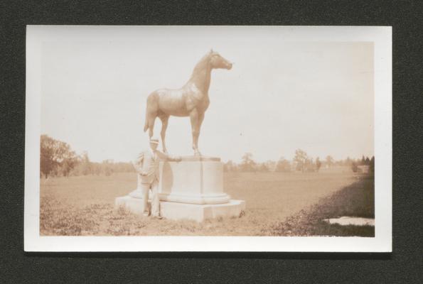 Man, possibly Samuel M. Wilson, standing in front of a statue of a horse