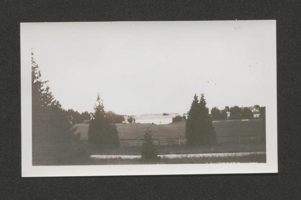 View from trees of a barn and pasture