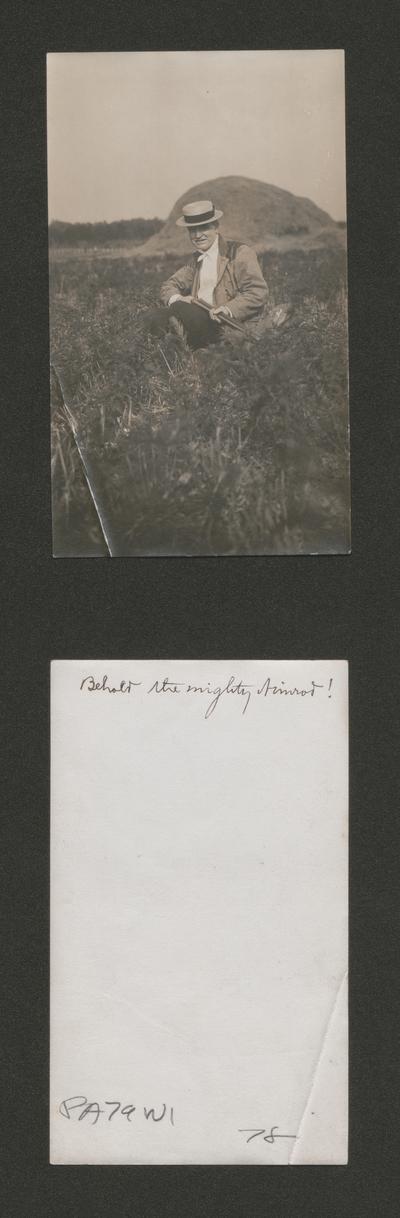 Samuel M. Wilson sitting in a field, holding a shotgun