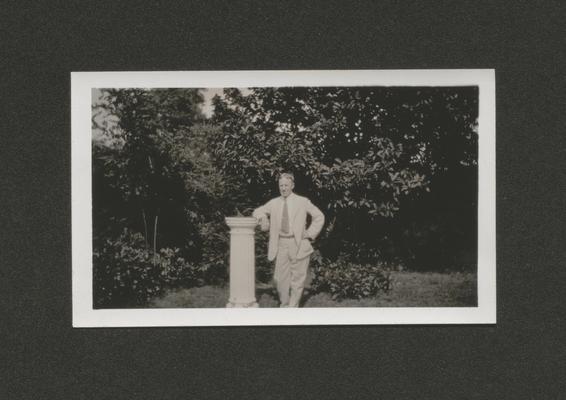 Man leaning on a sun dial