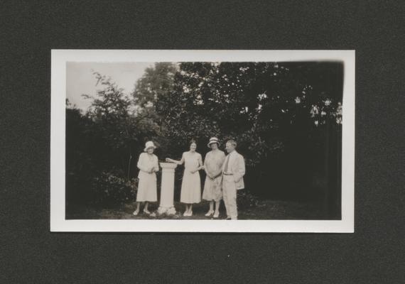 Mary Shelby Wilson, two woman, and a man standing by a sun dial